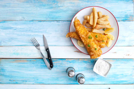 Traditional fish and chips on a plate over rustic wood tableの写真素材
