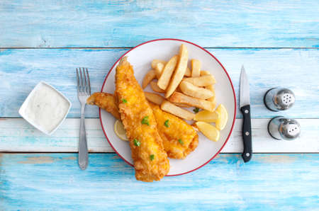 Traditional fish and chips on a plate over rustic wood tableの写真素材