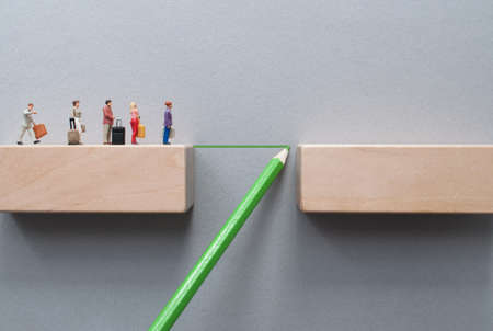 Miniiature travellers crossing a bridge drawn by green pencilの写真素材