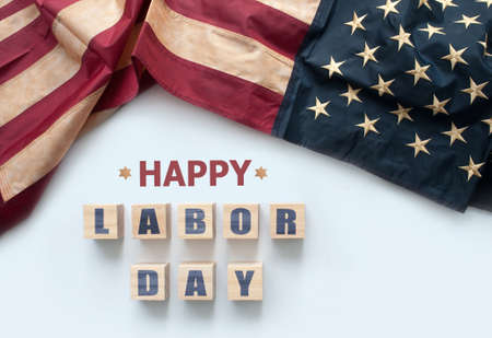 Happy labor day printed on wooden blocks with vintage American flagの写真素材