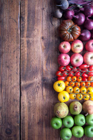 Selection of autumnal seasonal fruits and vegetables with rainbow colours on a rustic wooden backgroundの写真素材