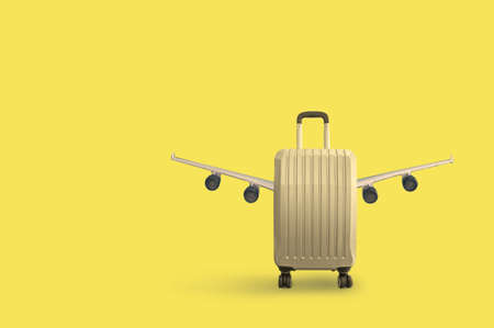 Cabin bag suitcase isolated on orange background with aircraft wingsの写真素材