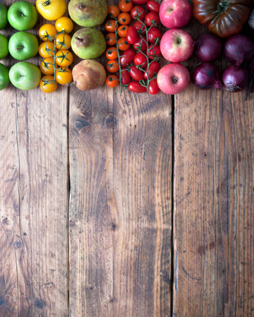 Selection of fruits and vegetables with rainbow colours on a rustic wooden background with space for textの写真素材