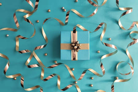 Christmas gift box wrapped with with decorative gold ribbon bowの写真素材