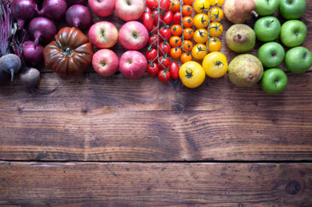 Selection of fruits and vegetables with rainbow colours on a rustic wooden backgroundの写真素材