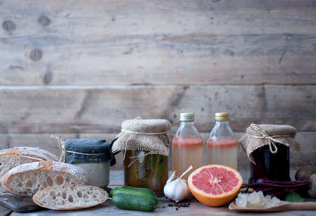 Rustic kitchen with homemade lacto fermented food, including cucumbers and beetroot, sourdough starter, with bread and water kefir with grainsの写真素材