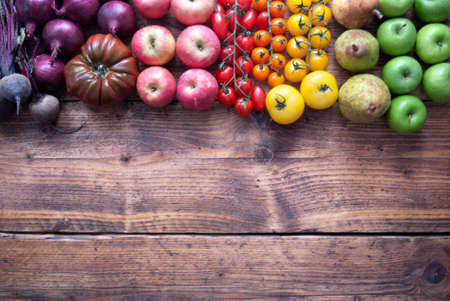 Selection of fruits and vegetables with rainbow colours on a rustic wooden backgroundの写真素材