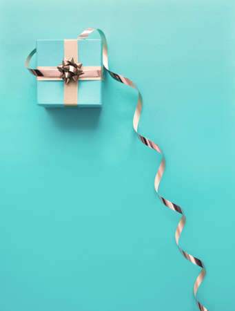 Seasonal gift box wrapped with with decorative gold ribbon bowの写真素材