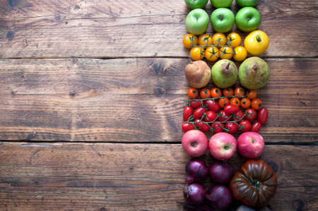 Selection of fruits and vegetables with rainbow colours on a rustic wooden backgroundの写真素材