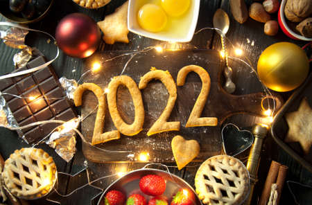 2022 made with pastry and fresh baking ingredients and decorative lightsの写真素材