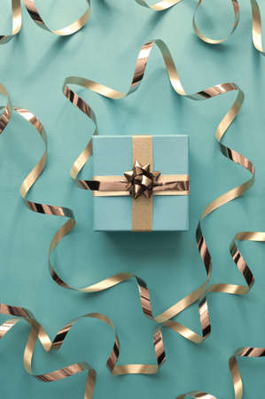Seasonal gift box wrapped with with decorative gold ribbon bowの写真素材