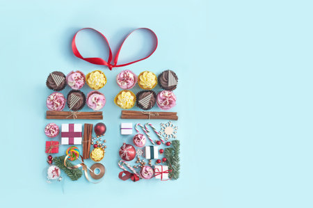 Collection of christmas seasonal objects and food in the shape of a gift box with decorative gold ribbon bowの写真素材