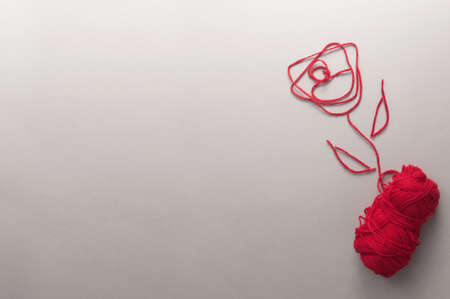 Red rose shaped using ball of wool yarnの写真素材