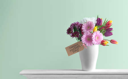 Mothers day spring flowers inside a pot on top of a fireplace mantelpiece with labelの写真素材