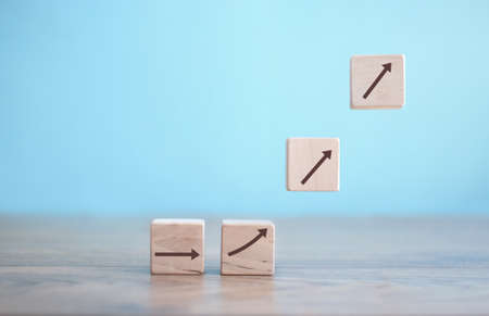 Business growth building blocks on podiums with arrows heading upwardsの写真素材