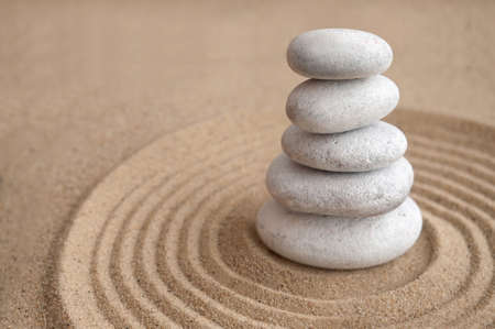 Yoga zen stones balanced on top of one another inside a sand circleの写真素材