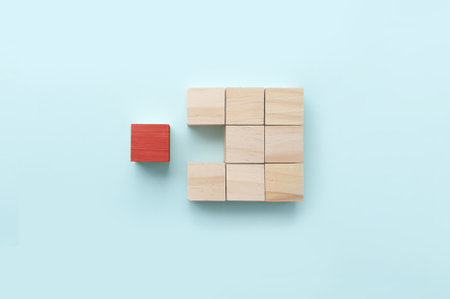 Red wooden block standing out amongst other pieces business concept
