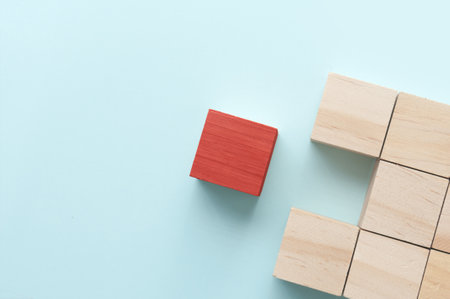 Red wooden block standing out amongst other pieces business conceptの写真素材
