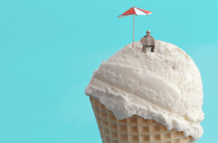 Miniature businessman reading newspaper on ice cream beach with parasol