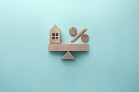 Miniature house and percentage sign balanced on a seesawの写真素材