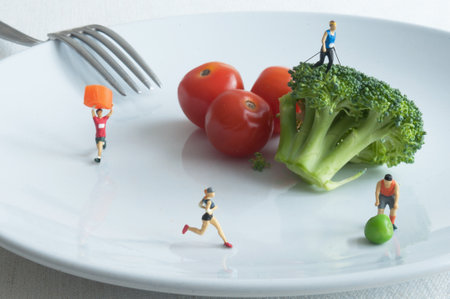 Miniature people working out on a plate with healthy nutritious foodの写真素材