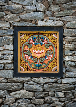 Ancient Oriental Carved Nepal Art on Brick Wall Backgroundの写真素材