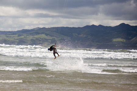 A kiteboarder takes to the air on a rainy dayの写真素材