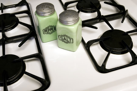 Antique salt and pepper shakers on a stoveの写真素材