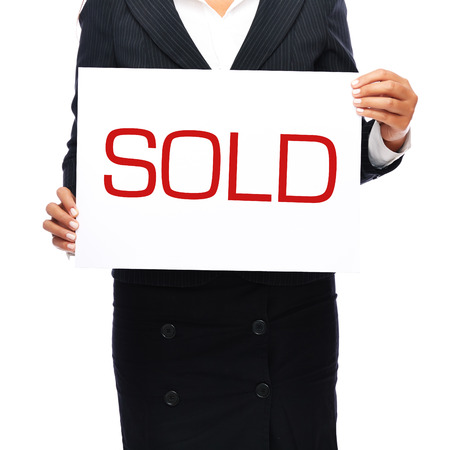 Businesswoman holding sold sign. Isolated on a withe background.
の写真素材