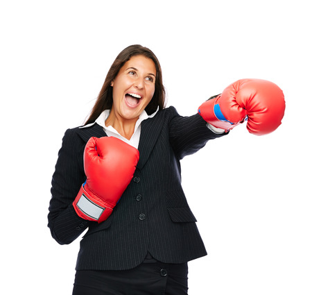 Business woman wearing boxing gloves is punching sideways.   Isolated on a white background.
の写真素材