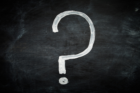 Question mark hand drawn on a blackboard with white chalk