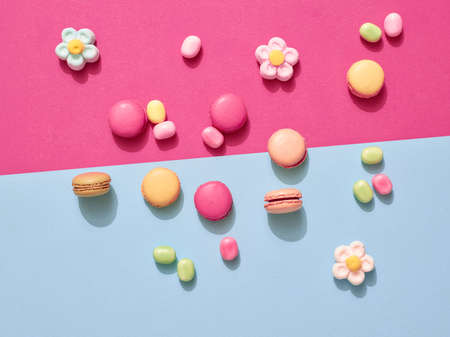 Delicious macarons with candies on a vibrant colorful background with copyspace