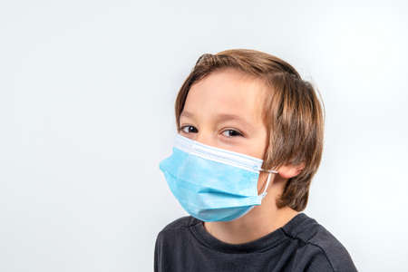 A young boy with a medical mask on a white background
