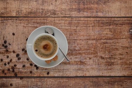 Drop falls into coffee cup on coffee beans, coffee spoon, biscuitsの写真素材