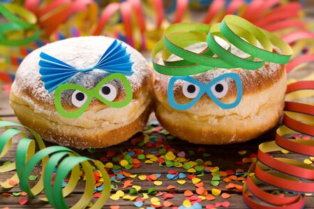 Carnival doughnuts with funny faces and paper streamersの写真素材