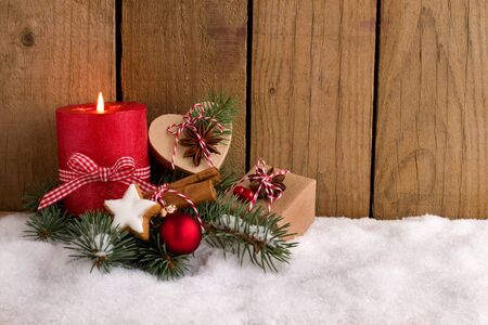 Christmas decoration - Red candle and cute presents in the snowの写真素材