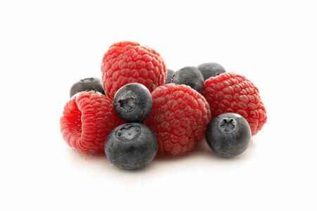 Raspberries and blueberries isolated against white