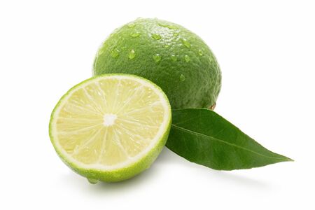 Fresh limes - one sliced - with drops of water isolated against whiteの写真素材