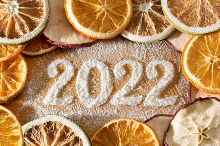 Turn of the year 2021/22 - Year date made of icing sugar with dried apple-, lime- and orange slicesの写真素材