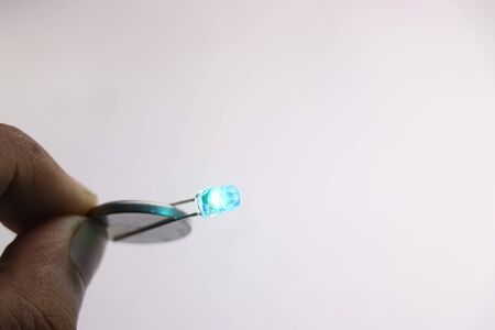 Coin battery is used to glow the blue led on white background