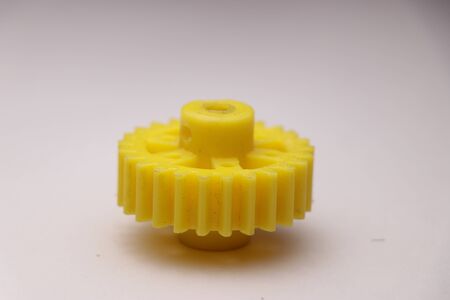 Plastic gear which is yellow in color and having teeth used in making projects attached to dc gear motorsの写真素材