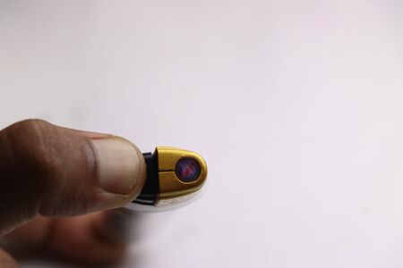 Flames visible from the lighter which is used to light cigarettes held in hand