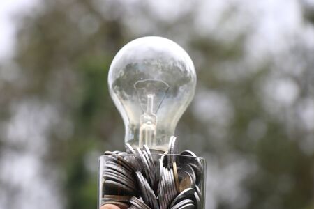 Pennies with glass bulb on its top showing ideas and innovation concept or growing business with money ideas conceptの写真素材