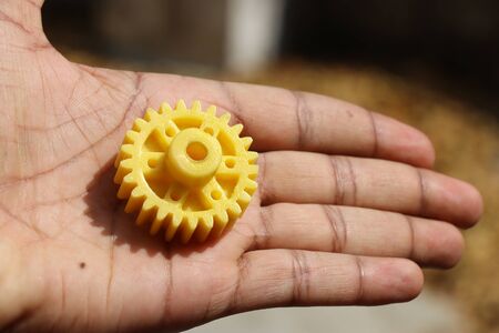 Yellow colored plastic gear wheels used mainly in mechanical motions and also in robotic projects which has a slot to be connected to motor shaftの写真素材