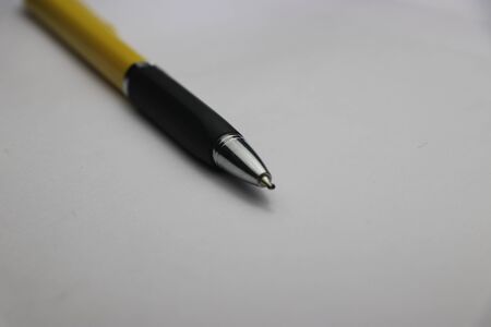 Ballpoint pen with black and yellow body used in writingの写真素材