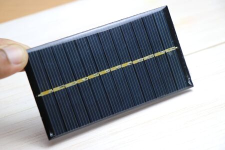 Mini solar panel also called as mini solar cell which is very small in size held in hand which produces electricity when exposed to sunlight is used to charge mini solar powered devicesの写真素材