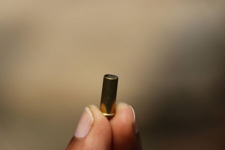 used bullet shell from revolver held in handの写真素材