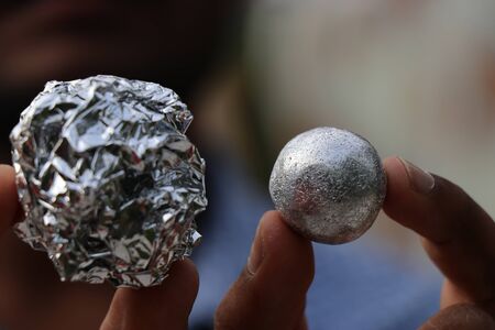 aluminium foil used in kitchen made to form clean ball held side for comparisonの写真素材