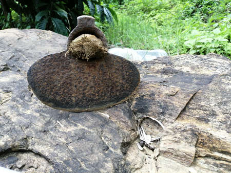 Old and antique style garden hoe with wooden handle kept on rock after hard labour at farmの写真素材