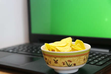 Work from home leisure concept with laptop and fast foodの写真素材